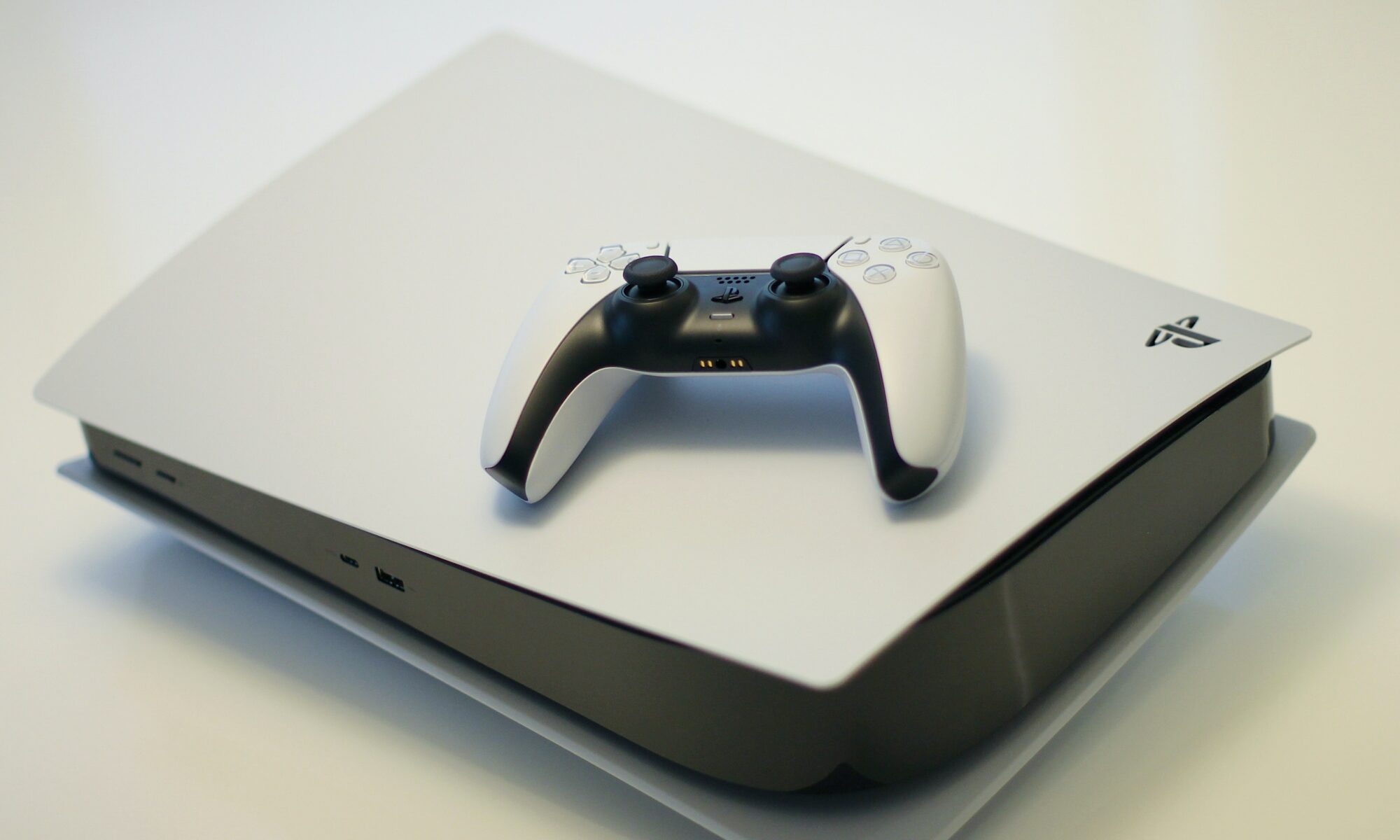 White Sony PS5 with its original controller on top