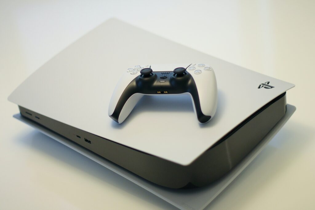 White colored sony playstation 5 on with a controller on top