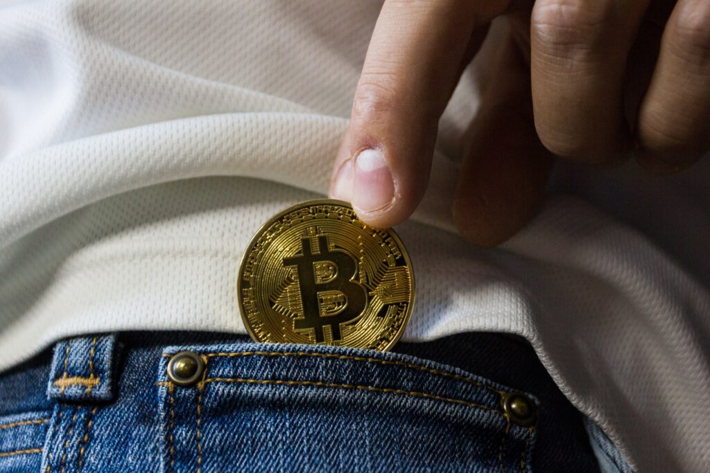 Gold bitcoin in a blue denim jeans.